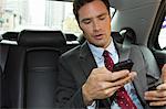Businessman in car with smartphone