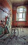 Broken chairs in decayed interior of Sanatorium Teupitz, Brandenburg, Germany