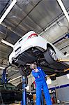 Technician working on car at automobile repair shop