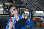 Mechanic analyzing car engine at auto repair shop