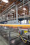 Orange juice bottles on conveyor in bottling plant