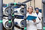 Two factory workers inspecting at bottling plant