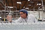 Quality control worker checking bottled water at bottling plant