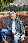 Portrait of lumberjack sitting on a pile of logs