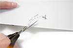 Hand using scissors to cut paper