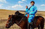 Junge mongolische Frauen in Tracht (Deel) Reiten Pferde, Provinz von Chowd, Mongolei, Zentralasien, Asien