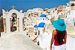 Tourist and church with blue dome, Oia (Ia) village, Santorini, Cyclades, Greek Islands, Greece, Europe