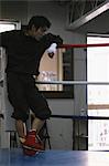 Boxer Leaning Against Rope in Boxing Ring