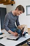 Man working on clipboard and laptop