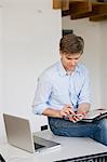 Businessman using cell phone in office