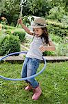 Girl playing with hula hoop in backyard