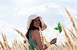 Woman holding pinwheel in wheatfield