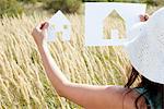 Woman holding paper house cut outs