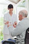 Nurse giving older patient medication