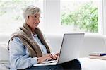 Smiling older woman using laptop