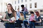 Étudiant portant des livres sur le campus