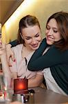 Smiling women hugging in cafe