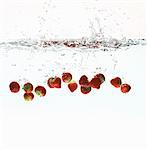 Strawberries splashing in water