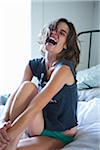 Woman Sitting on Bed Laughing