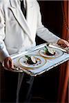 Waiter carrying a tray with two plates of stuffed cabbage with lentils