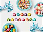 Happy Birthday written on Smarties and paper cup full of sugar balls for decorating cakes