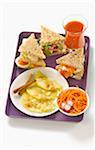 T.V dinner tray with grated carrot salad,sandwiches and pineapple with cinnamon