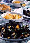 Mussels and chips on table outdoors