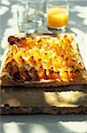 Apricot tart with glass of orange juice