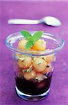 Small melon balls with blackberry coulis and basil