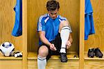 Young soccer player tying shoe