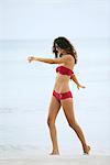 Woman in bikini walking in surf at the beach