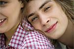 Young man resting head on girlfriend's shoulder, cropped portrait