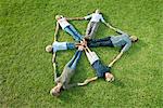 People on grass forming shape of shield