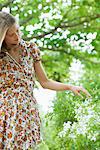 Young woman touching wildflowers