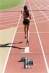 Woman running on track, rear view