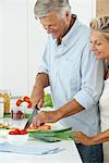 Mature couple preparing food together in kitchen