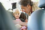 Father fastening little girl into car seat