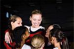 Team of female gymnasts embracing