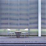 Table and chairs in front of a facade