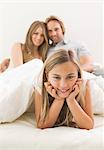 Smiling girl in bed of her parents