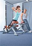 Man looking at woman exercising in health club