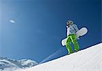 Homme debout avec snowboard à halfpipe