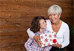 Senior woman and grandchild with a Christmas present