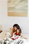 Mother and daughter reading in bed