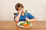 Boy frowning at vegetables