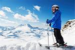 Boy in skis on snowy mountaintop