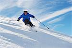 Garçon de ski sur le flanc de la montagne enneigée