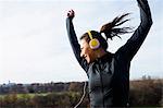 Woman in headphones dancing outdoors