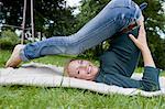 Femme qui s'étend sur couverture en herbe