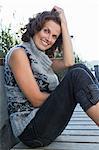 Smiling woman sitting on pier